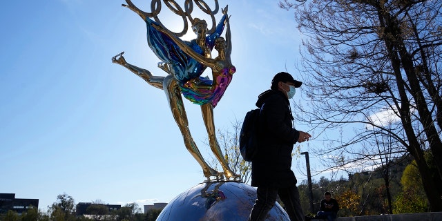 A visitor to the Shougang Park walks past a sculpture for the Beijing Winter Olympics in Beijing, China, Tuesday, Nov. 9, 2021. 