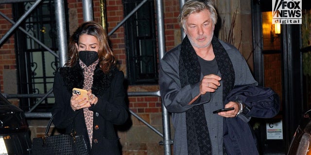 Alec Baldwin and his wife Hilaria are pictured leaving their apartment on the day authorities obtained a search warrant requesting the actor hand over his phone.