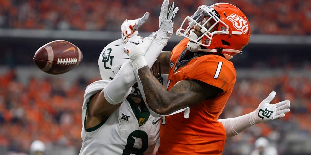 Tay Martin (1) of the Oklahoma State Cowboys has a pass in the end zone knocked away by Jalen Pitre (8) of the Baylor Bears in the first half of the Big 12 Football Championship Dec. 4, 2021 在阿灵顿, 德州.