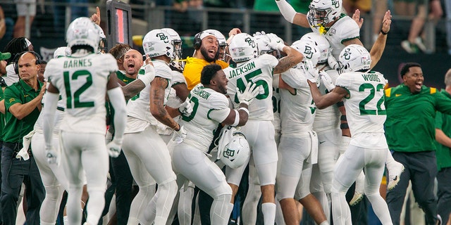 Baylor Bears players celebrate on the sidelines after a play against the Oklahoma State Cowboys Dec. 4th, 2021 in Arlington, Texas.