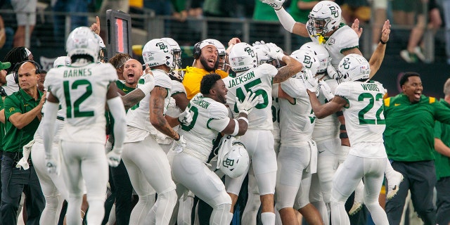Baylor Bears players celebrate on the sidelines after a play against the Oklahoma State Cowboys Dec. 4日, 2021 在阿灵顿, 德州.