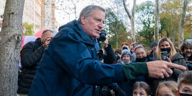 Mayor Bill de Blasio greets spectators during 95th Macy's Thanksgiving Day parade balloon inflation on West 81st street.