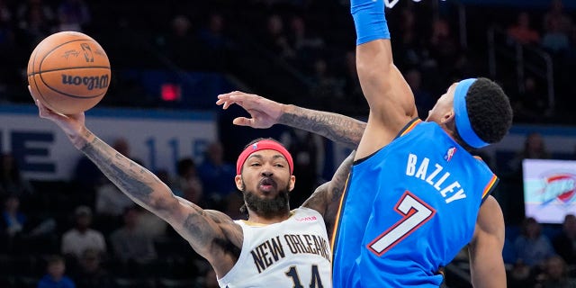 New Orleans Pelicans forward Brandon Ingram (14) passes around Oklahoma City forward Darius Bazley (7) in the second half of an NBA basketball game Wednesday, 12月. 15, 2021, in Oklahoma City.