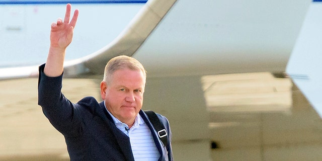 New LSU football coach Brian Kelly gestures to fans after his arrival at Baton Rouge Metropolitan Airport, Tuesday, Nov. 30, 2021, in Baton Rouge, Louisiana. 