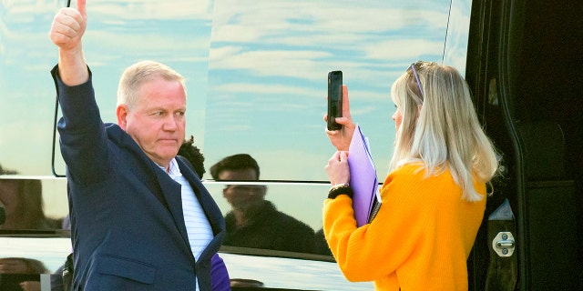 New LSU football coach Brian Kelly gestures to fans after his arrival at Baton Rouge Metropolitan Airport, Tuesday, Nov. 30, 2021, in Baton Rouge, Louisiana.