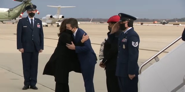 Vice President Kamala Harris and Transportation Secretary Pete Buttigieg embrace each other before traveling to North Carolina to talk about the two-part infrastructure law on Thursday, December 2, 2021.