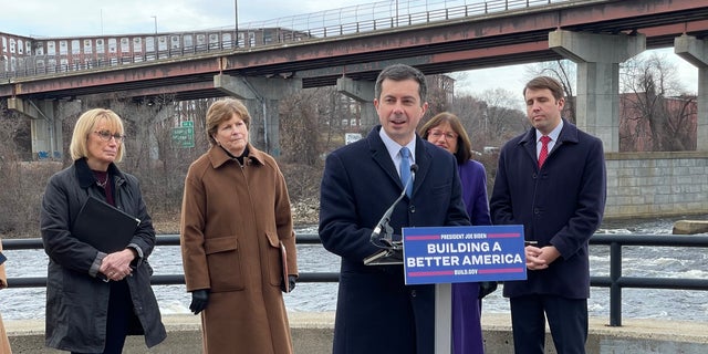 Transport Secretary Pete Buttigig, joined by a delegation from the New Hampshire Democratic Congress (left to right: Senators Maggie Hassan and Jeanne Shahin, and Annie Custer and Chris Papas), speaks at a news conference in Manchester, New York, 13 December.  2021
