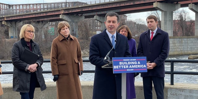 Transportation Secretary Pete Buttigieg, joined by New Hampshire's all Democratic congressional delegation (L to R: Sens. Maggie Hassan and Jeanne Shaheen, and Reps. Annie Kuster and Chris Pappas), speaks at a news conference in Manchester, NH on Dec. 13, 2021