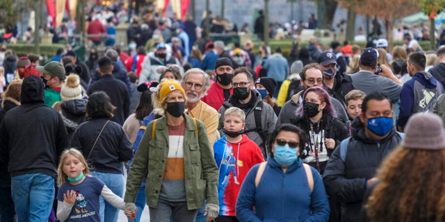 Visitors wearing face masks walk down Main Street USA at Disneyland in Anaheim, 加利福尼亚州, 星期一, 十二月. 27, 2021. (美联社照片/ Ringo H.W. u)