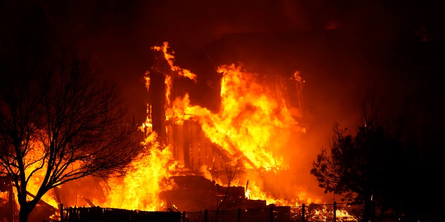Homes burn as a wildfire rips through a development near Rock Creek Village, Thursday, Dec. 30, 2021, near Broomfield, Colorado. An estimated 580 homes, a hotel and a shopping center have burned and tens of thousands of people were evacuated in wind-fueled wildfires outside Denver, officials said Thursday evening.