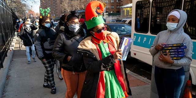 Sharil Jones, Executive Director of the Dewitt Reformed Church Head Start, picks up a test kit that detects COVID-19 as they are distributed in the Lower East Side neighborhood of Manhattan in New York Thursday, Dec. 23, 2021.