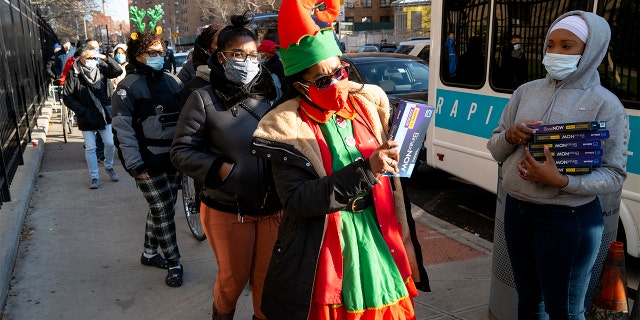 Sharil Jones, Executive Director of the Dewitt Reformed Church Head Start, picks up a test kit that detects COVID-19 as they are distributed in the Lower East Side neighborhood of Manhattan in New York Thursday, Dec. 23, 2021.