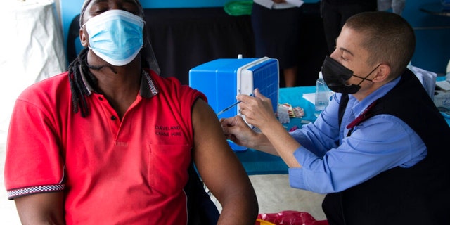 A man gets vaccinated against COVID-19 at a site near Johannesburg, Monday, Dec. 13, 2021, a day after South African President Cyril Ramaphosa tested positive receiving for mild COVID-19 symptoms after testing positive for the disease.  