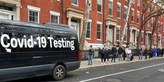 A line stretches down the block as people wait in line to be tested for COVID-19 in New York on Thursday, Dec. 16, 2021.  
