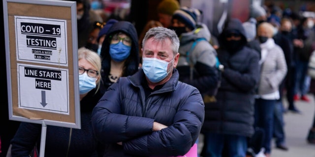 FILE - People wait in line at a COVID-19 testing site in New York' Times Square on Dec. 13, 2021. More than a year after the vaccine was rolled out, new cases of COVID-19 in the U.S. have soared to their highest level on record at over 265,000 per day on average, a surge driven largely by the highly contagious omicron variant. (AP Photo/Seth Wenig, File) 