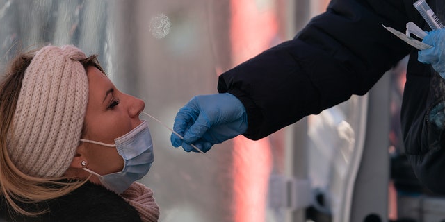 一名医护人员在美国纽约时代广场的移动测试站点进行 Covid-19 测试鼻拭子 Gina Moon/Bloomberg via Getty Images