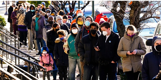 City residents wait in a line extending around the block to receive free at-home rapid COVID-19 test kits in Philadelphia, Monday, Dec. 20, 2021. 