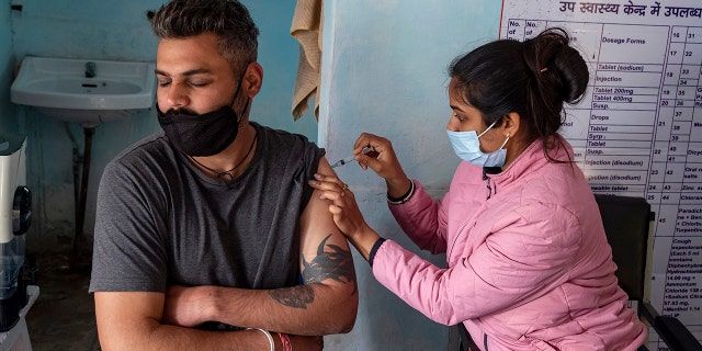 A man closes his eyes as he receives a Covishield vaccine for COVID-19 at a Primary Health Centre in Dharmsala, India, Friday, Dec. 3, 2021.