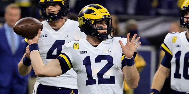 Cade McNamara #12 of the Michigan Wolverines warms up before the Big Ten Football Championship game against the Iowa Hawkeyes at Lucas Oil Stadium on December 04, 2021 in Indianapolis, Indiana.