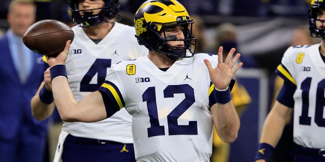 Cade McNamara #12 of the Michigan Wolverines warms up before the Big Ten Football Championship game against the Iowa Hawkeyes at Lucas Oil Stadium on December 04, 2021 in Indianapolis, Indiana.