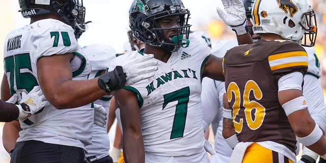 十一月 27, 2021; Laramie, 怀俄明州, 美国; Hawaii Rainbow Warriors running back Calvin Turner Jr. (7) celebrates a touchdown against the Wyoming Cowboys during the second quarter at Jonah Field at War Memorial Stadium.