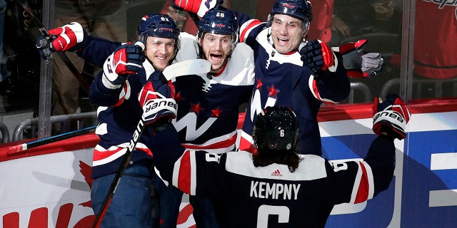 Washington Capitals' Nic Dowd, center, celebrates with teammates Carl Hagelin, left, Garnet Hathaway, right, and Michal Kempny (6) after scoring a goal against Nashville Predators goalie Juuse Saros (74) during the first period of an NHL hockey game, Wednesday, Dec. 29, 2021, in Washington.