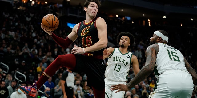 Cleveland Cavaliers' Cedi Osman passes around Milwaukee Bucks' DeMarcus Cousins and Jordan Nwora during the first half of an NBA basketball game Saturday, Dec. 18, 2021, in Milwaukee.