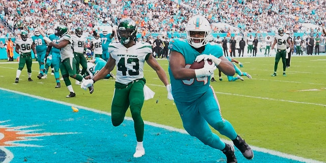 Miami Dolphins defensive end Christian Wilkins (94) scores a touchdown after New York Jets linebacker Del'Shawn Phillips (43) missed a tackle during the second half Sunday, 十二月. 19, 2021, in Miami Gardens, 弗拉.