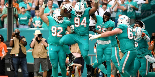 Christian Wilkins (94) of the Miami Dolphins celebrates with teammates after scoring on a touchdown reception against the New York Jets in the fourth quarter at Hard Rock Stadium Dec. 19, 2021 a Miami Gardens, Fla.