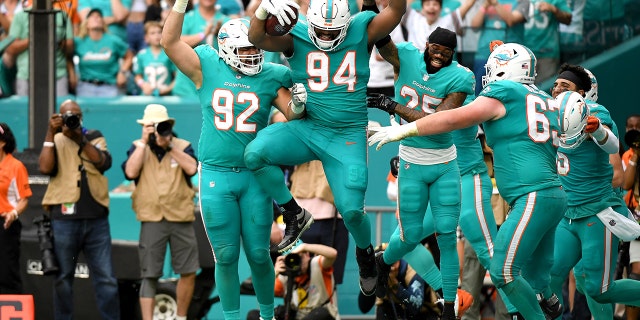 Christian Wilkins (94) of the Miami Dolphins celebrates with teammates after scoring on a touchdown reception against the New York Jets in the fourth quarter at Hard Rock Stadium Dec. 19, 2021 a Miami Gardens, Fla.