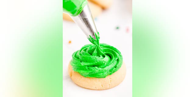 Pipe (or spread) frosting onto the top of the largest size cookie, and place the middle size cookie on top.