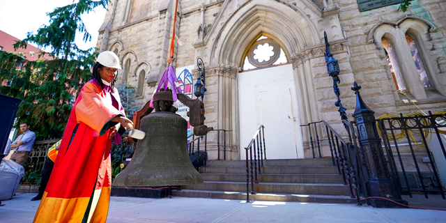 Senior Minister Rev. Jacqueline J. Lewis rings New York's Liberty Bell after a crew lowered it from Middle Collegiate Church's bell tower on June 16, 2021, in the East Village neighborhood of New York. 