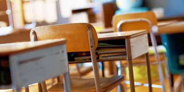 Classroom with empty wooden desks.