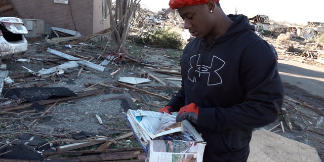 Ja-sean Kocatow finds a yearbook in the rubble of his Mayfield, Kentucky backyard