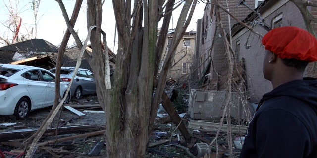 Mayfield, Kentucky resident Ja-sean Kocatow looks at tornado damage
