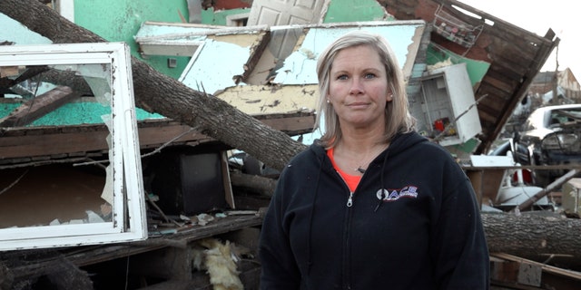 Danielle Kemp stands in front of tornado aftermath