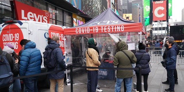 People line up for a Covid-19 test at a mobile test site in Times Square on December 28, 2021 in New York City. (Photo by Bryan R. Smith / AFP) (Photo by BRYAN R. SMITH / AFP via Getty Images)