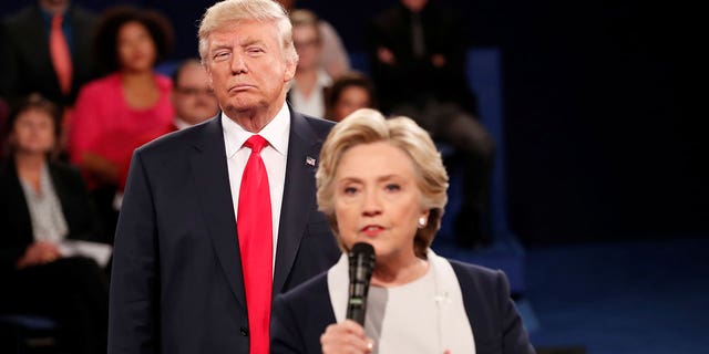 Republican U.S. presidential nominee Donald Trump listens as Democratic nominee Hillary Clinton answers a question from the audience during their presidential town hall debate at Washington University in St. Louis, Missouri, U.S., October 9, 2016.