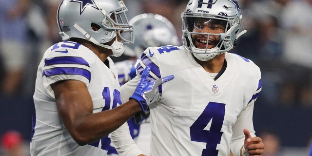 Dak Prescott #4 of the Dallas Cowboys celebrates with Amari Cooper #19 after a touchdown during the fourth quarter against the New York Giants at AT&versterker;T Stadium on October 10, 2021 in Arlington, Texas.