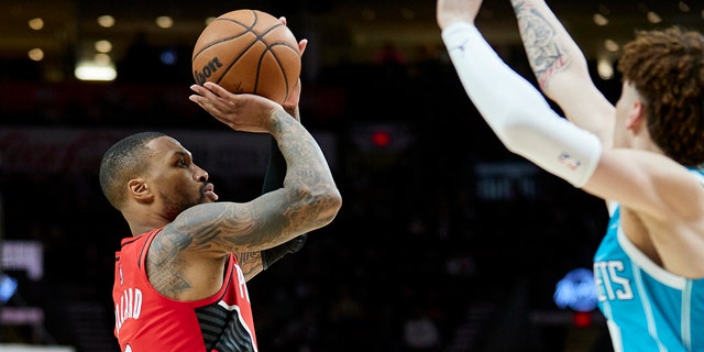 Damian Lillard (left) of the Portland Trail Blazers Guard shoots the Charlotte Hornets Guard's LaMelo Ball later in the match on December 17, 2021 in Portland, Oregon.