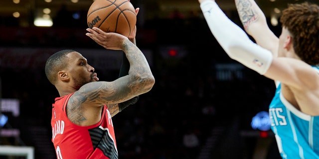 Damian Lillard (left) of the Portland Trail Blazers Guard shoots the Charlotte Hornets Guard's LaMelo Ball later in the match on December 17, 2021 in Portland, Oregon.