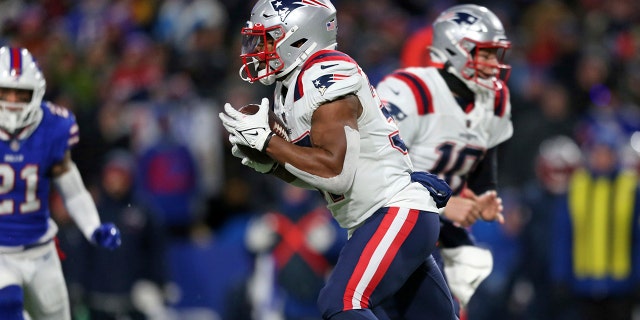 New England Patriots running back Damien Harris, center, takes a hand off from New England Patriots quarterback Mac Jones (10) for a touchdown during the first half of an NFL football game against the Buffalo Bills in Orchard Park, N.Y., Monday, Dec. 6, 2021. ()
