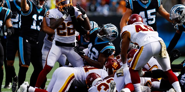 Sam Franklin #42 of the Carolina Panthers and Deshazor Everett #22 of the Washington Football Team gets into a scrum in the second quarter of the game at Bank of America Stadium on November 21, 2021 in Charlotte, North Carolina.