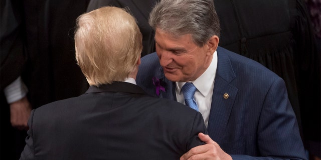 FILE - President Trump embraces Sen. Joe Manchin, Democrat of West Virginia, after speaking during the State of the Union Address at the U.S. Capitol in Washington, Jan. 30, 2018. (Photo: SAUL LOEB/AFP via Getty Images)