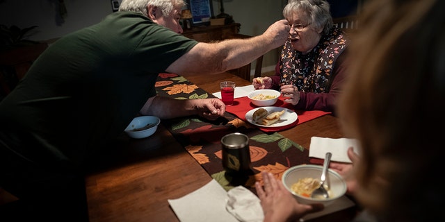 Jimmy Ryder feeds his mother-in-law, Betty Bednarowski, during dinner, Monday, Nov. 29, 2021, in Rotterdam Junction, New York.