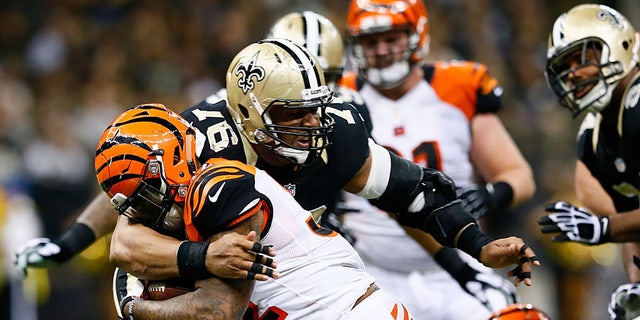 Glenn Foster, #97 of the New Orleans Saints, tackles Jeremy Hill, #32 of the Cincinnati Bengals, during the second half against the New Orleans Saints at Mercedes-Benz Superdome on Nov. 16, 2014 in New Orleans.