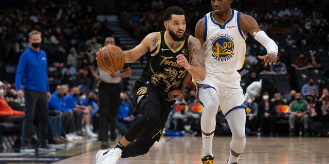 Toronto Raptors' Fred VanVleet (23) drives at Golden State Warriors' Jonathan Kuminga during the first half of an NBA basketball game, Saterdag, Des. 18, 2021 in Toronto.