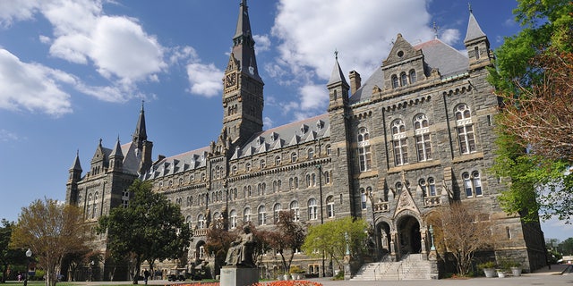 "Washington, D.C., USA - April 9, 2012. Healy Hall with the statue of Georgetown University founder John Carroll in front and some people walking in background. Georgetown University is a top-ranking private university in the United States. 