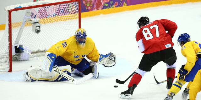 Sidney Crosby of Canada scores the 2-0 against goal keeper Henrik Lundqvist (L) of Sweden during the Men's Ice Hockey Gold Medal match Sweden vs Canada in Bolshoy Ice Dome at the Sochi 2014 Olympic Games, Sochi, Russia, 23 February 2014.