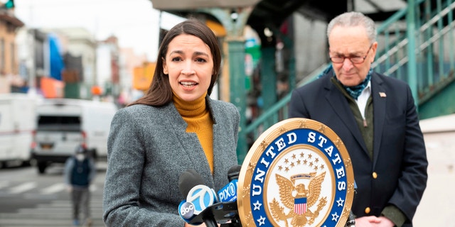 Rep. Alexandria Ocasio-Cortez, D-N.Y., speaks as Sen. Chuck Schumer, D-N.Y., listens during a press conference in the Corona neighborhood of Queens on April 14, 2020 in New York City. (Photo by JOHANNES EISELE/AFP via Getty Images)